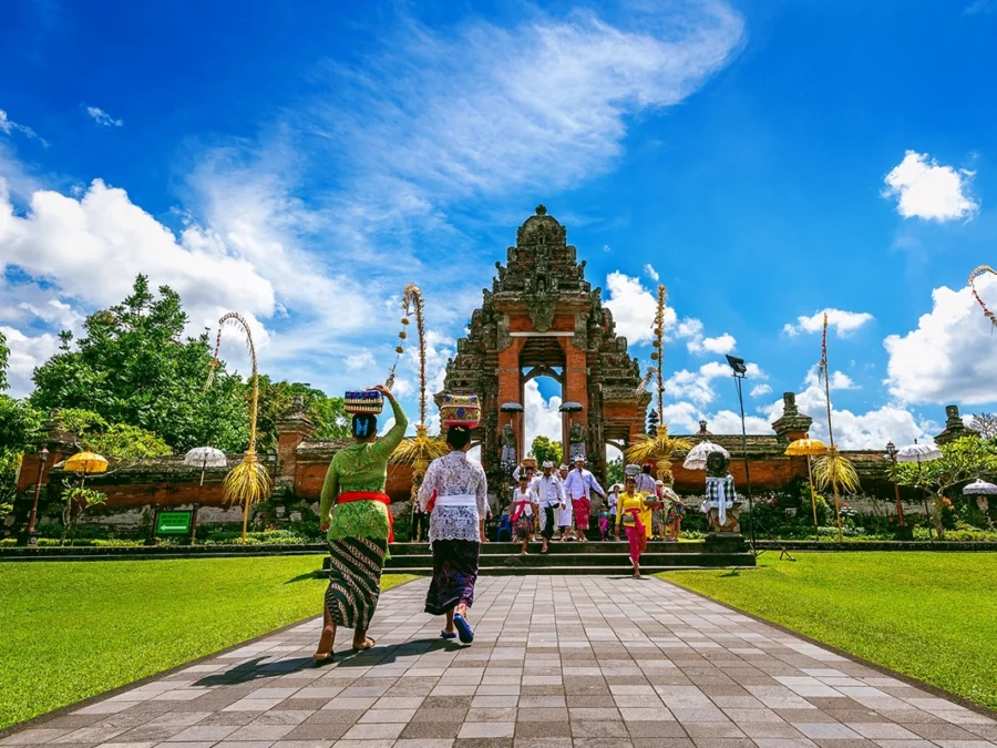 balinese people in traditional clothes during religious ceremony at pura taman